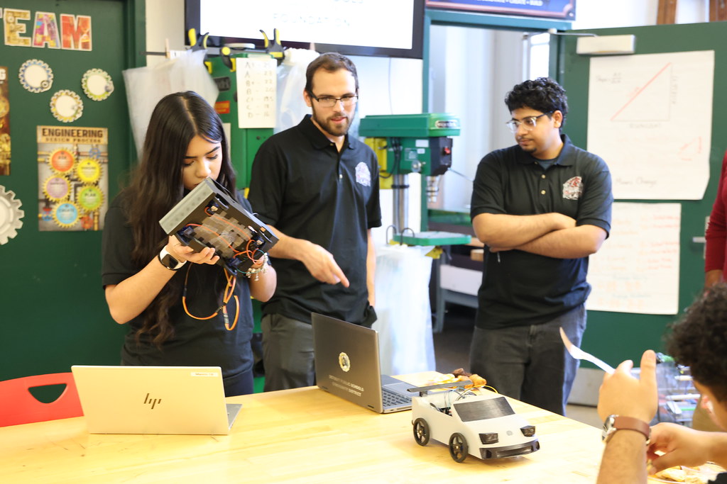Students show a model vehicle built in the Ford Future Builders Lab