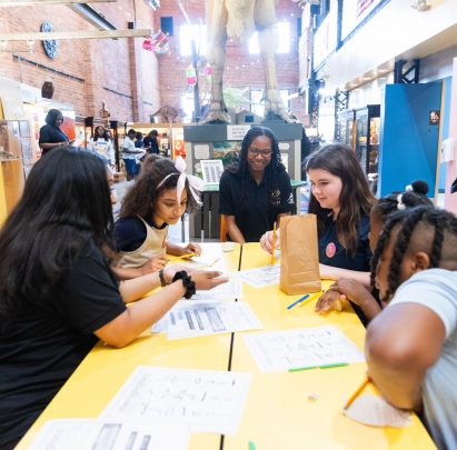 Detroit students taking part in a hands-on activity with a guide at Detroit's Children Museum